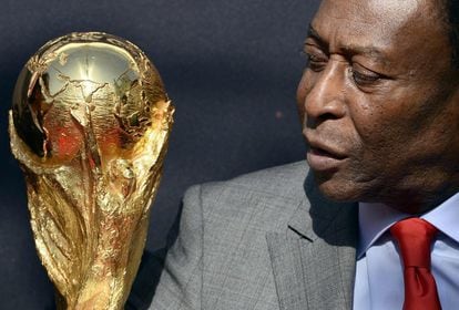 Pelé observa el trofeo de la Copa Mundial durante un evento en París, en 2014.