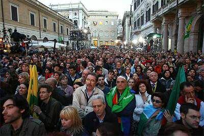 Seguidores de Romano Prodi siguen el recuento electoral en una pantalla gigante en el centro de Roma.