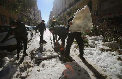 Varios vecinos retiraban el martes placas de hielo de la calzada en una calle del centro de Madrid.