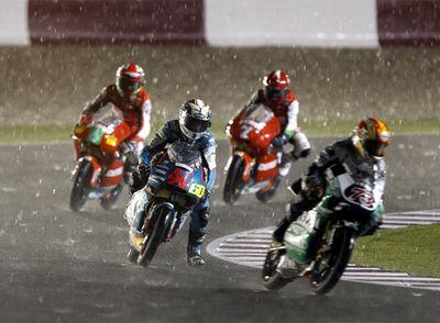 Cuatro pilotos intentan controlar sus motos bajo la lluvia en la carrera de 125cc.