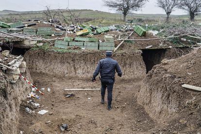 Un policía azerbaiyano inspecciona los túneles de una posición fortificada excavada tras una colina y abandonada por las fuerzas armenias durante la última guerra. Las cajas desperdigadas son de munición de mortero de fabricación rusa.