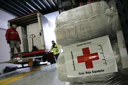 Voluntarios de Cruz Roja cargan ayuda humanitaria para la franja de Gaza.