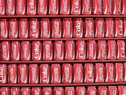 Estanter&iacute;a con latas de Coca-Cola.