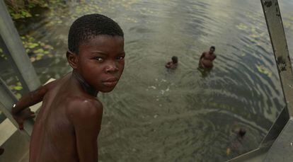 Unos niños se refrescan en un estanque de Magude. Las zonas con agua favorecen la propagación del mosquito trasmisor de la malaria.