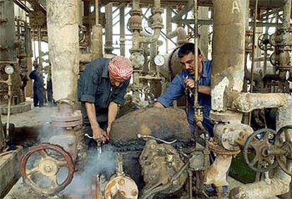 Dos trabajadores iraquíes reparan en mayo de 2003 la refinería de Al Daura, cerca de Bagdad.