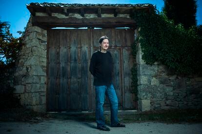 El escritor Santiago Lorenzo posa ante un portón en el pueblo segoviano donde reside. 

