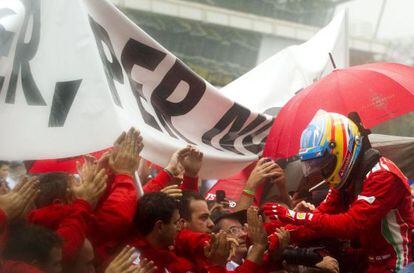 Alonso saluda a sus mecánicos al concluir la carrera.