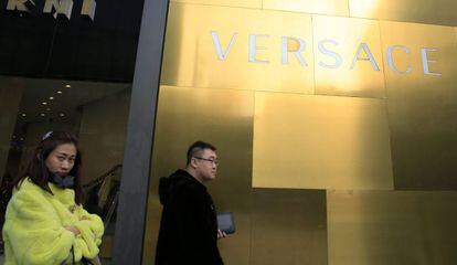 Un grupo de personas camina frente a una tienda de lujo en Pek&iacute;n (China), el 25 de febrero de 2016.