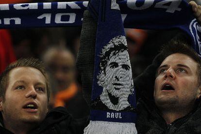 Unos espectadores exhiben una bufanda con la imagen de Raúl en el partido con el Valencia.