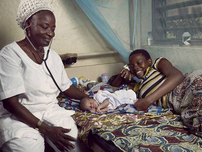 Antoinette Sossa Epse, enfermera de un centro de salud en la ciudad beninesa de Athiémé, examina al recién nacido de Matilde Tchito bajo su atenta mirada.