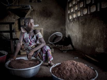 Una joven espera su turno para continuar moliendo el karité en la cooperativa de Fo-Bouré (Benín).