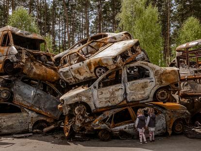 Unos niños observan los vehículos destruidos en Irpin, Ucrania, el pasado 8 de mayo.