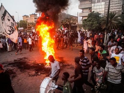 Manifestantes sudaneses corean consignas junto a neumáticos ardiendo durante una manifestación en la capital, este martes en Jartum, Sudán.