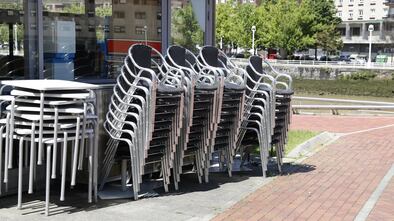 Sillas y mesas apiladas de un restaurante sin actividad en Bilbao.