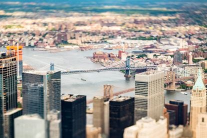 Los puentes de Brooklyn y de Manhattan (enfocados) vistos desde los rascacielos del sur de Manhattan. Al fondo, el barrio de Queens.