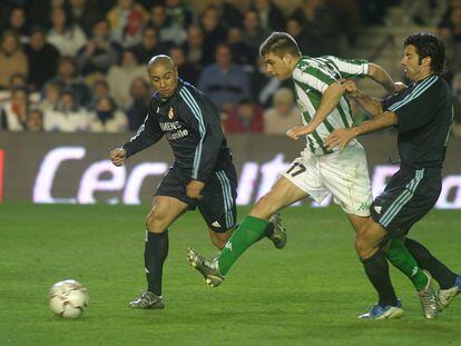 Joaquín dispara entre Roberto Carlos y Figo en el Betis-Real Madrid de enero de 2004 (1-1).