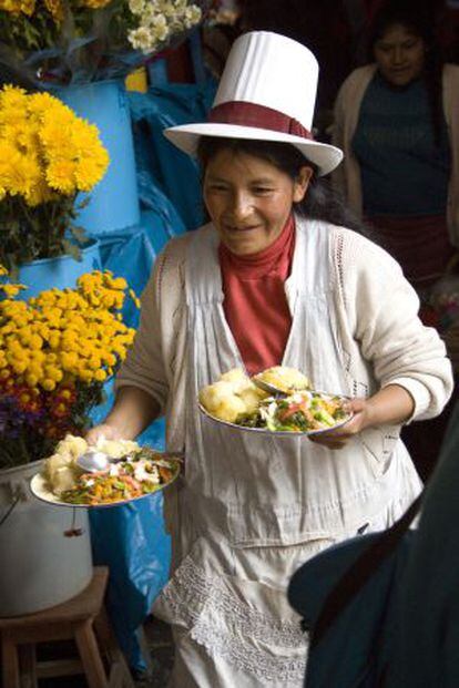 Una mujer sirviendo comida en un mercado de  Cuzco.