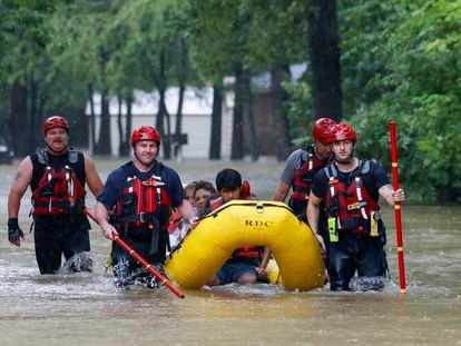 Bomberos de la ciudad de Balch Springs, al este de Dallas, auxilian a una familia tras las lluvias torrenciales de este fin de semana.