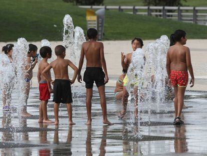 Un grupo de niños se refresca este martes en el parque madrileño de Juan Carlos I.