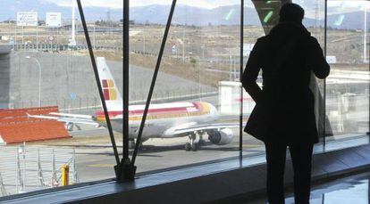 Un pasajero observa un avi&oacute;n de Iberia en el aeropuerto de Barajas en Madrid.