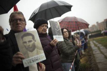 Un familiar levanta la foto de un represaliado en la Guerra Civil. FOTO: PACO PUENTES/EL PAIS