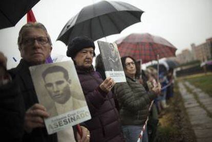 Un familiar levanta la foto de un represaliado en la Guerra Civil.  FOTO: PACO PUENTES/EL PAIS