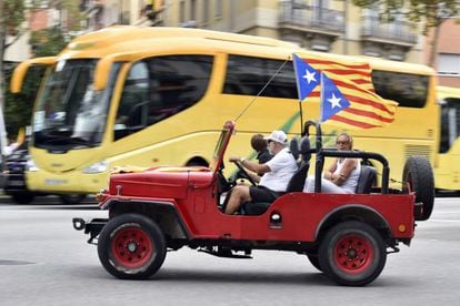 Un vehículo con banderas independentistas se dirige a las celebraciones de la Diada en Barcelona.