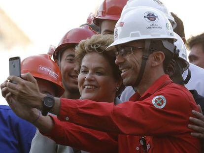 Dilma posa para fotos con trabajador de la Arena Corinthians.