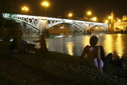 Las altas temperaturas nocturnas hicieron que numerosas personas se acercaran al Guadalquivir en Sevilla a refrescarse y pasar la noche el 11 de agosto.