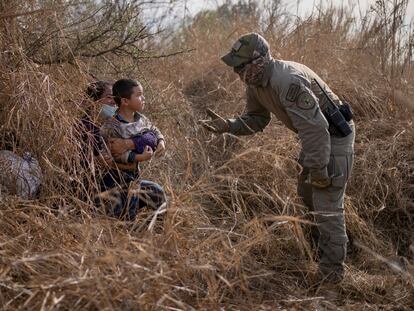 Un policía texano conversa con una solicitante de asilo hondureña y su hijo de 4 años después de que estos cruzaran el Río Bravo el 9 de marzo en Peñitas, en el Valle del Río Grande.