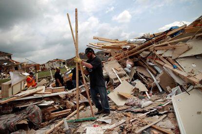 Vecinos de Forney, en Tejas, recogen los escombros de sus hogares tras el paso de los tornados.