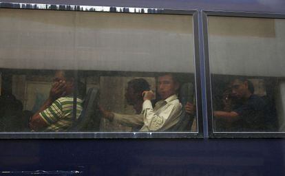 Inmigrantes en un autobús policial, el día 5 en Atenas.