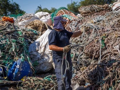 Un trabajador selecciona cuerdas para que se trituren y sean recicladas.