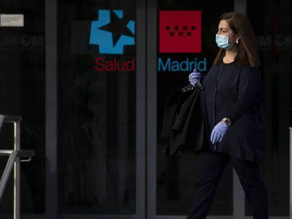 Una mujer sale del Hospital La Paz, en Madrid, protegida con guantes y mascarilla. / PABLO BLAZQUEZ (GETTY IMAGES)