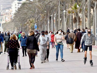 Varias personas pasean por el Paseo Marítimo de Almería con mascarillas durante la pandemia.