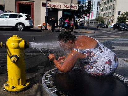Una mujer se refresca este miércoles en Skid Row, en el centro de Los Ángeles.