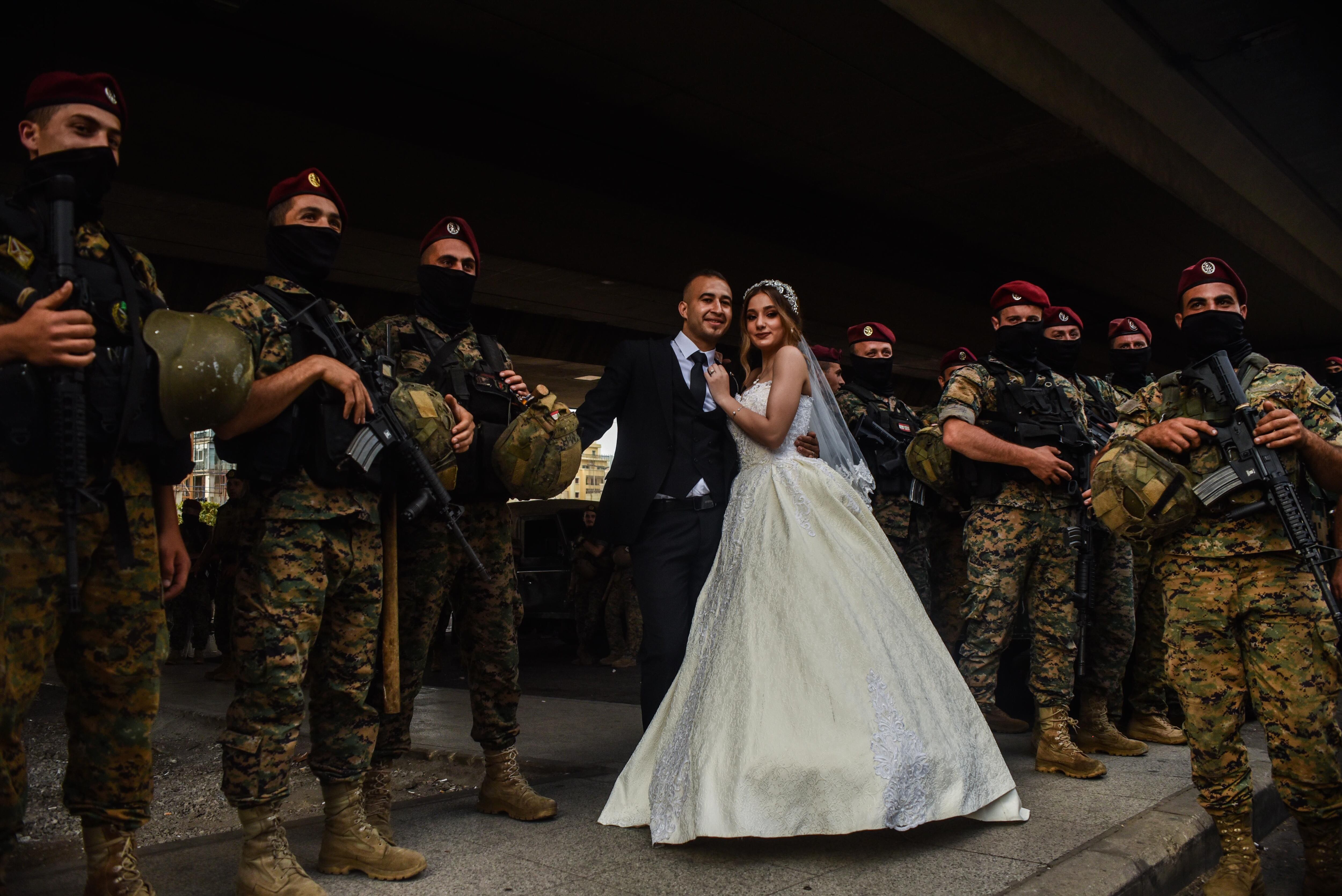 Una pareja de recién casados posa este sábado en Beirut entre manifestantes y fuerzas especiales del Ejército libanés desplegados para contener la batalla campal.