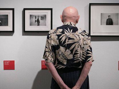 Duane Michals miratres de les seves fotografies a l'exposició.