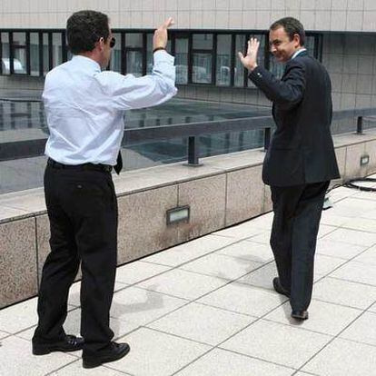 Sarkozy y Zapatero se saludan en un descanso de la cumbre de Bruselas.