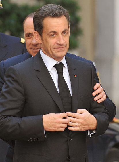Silvio Berlusconi (detrás) da la bienvenida a Nicolas Sarkozy ayer en la sede presidencial, en Roma.