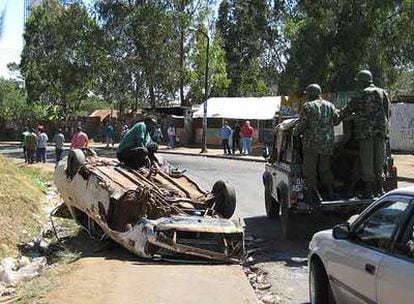 Un coche de la policía antidisturbios keniana sortea una de las barricadas de Kibera tras alcanzar una tregua con sus habitantes.