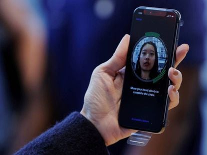 FILE PHOTO: A woman sets up her facial recognition as she looks at her Apple iPhone X at an Apple store in New York, U.S., November 3, 2017. REUTERS/Lucas Jackson/File Photo
