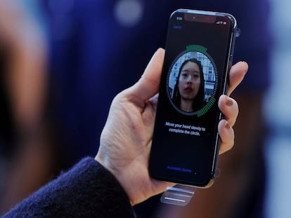 FILE PHOTO: A woman sets up her facial recognition as she looks at her Apple iPhone X at an Apple store in New York, U.S., November 3, 2017. REUTERS/Lucas Jackson/File Photo