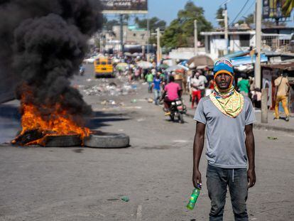 Factory workers demanding a salary increase, burn tires to protest in Port-au-Prince, Haiti, on February 16, 2022. - Workers employed in factories that produce textiles and other goods say they earn 500 gourdes ($5) per day for nine hours of work and require a minimum of 1,500 gourdes ($15) per day. (Photo by Richard Pierrin / AFP)