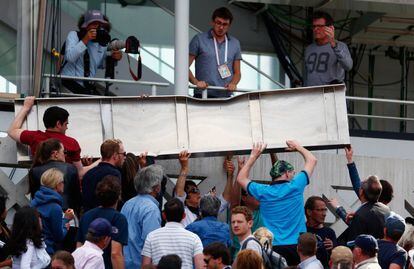 Los espectadores ayudan a retirar la placa.