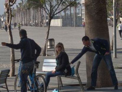 Un carterista roba a una turista en la Barceloneta mientras otro la distrae.