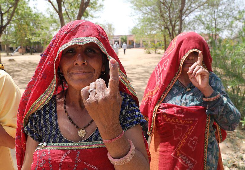 Dos mujeres indias enseñan sus dedos marcados tras votar en un colegio electoral en el pueblo de Shahpura, a las afueras de Jaipur (India), este viernes.
