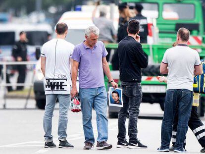 El padre de una víctima sujeta un retrato de su hijo cerca del centro comercial Olympia, Múnich (Alemania), el 23 de julio de 2016.