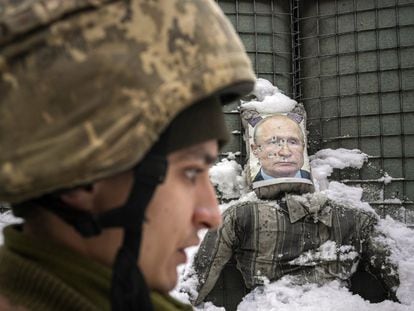 Un militar ucranio, al fondo un muñeco con el rostro de Putin acribillado a balazos.