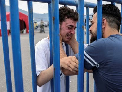 Un superviviente sirio (izquierda) llora junto a su hermano, llegado de Italia para buscarlo tras el naufragio, el viernes en el puerto griego de Kalamata.